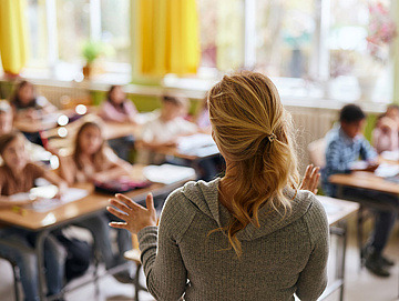 Eine Frau steht vor einer Schulklasse