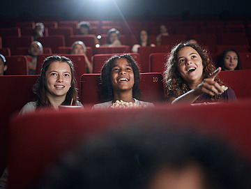 Drei Kinder in einem Kinosaal